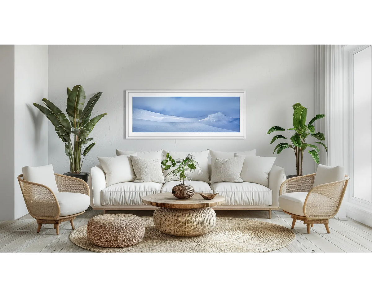 Isolated. Snow wall art print, with a white frame, above a couch. 