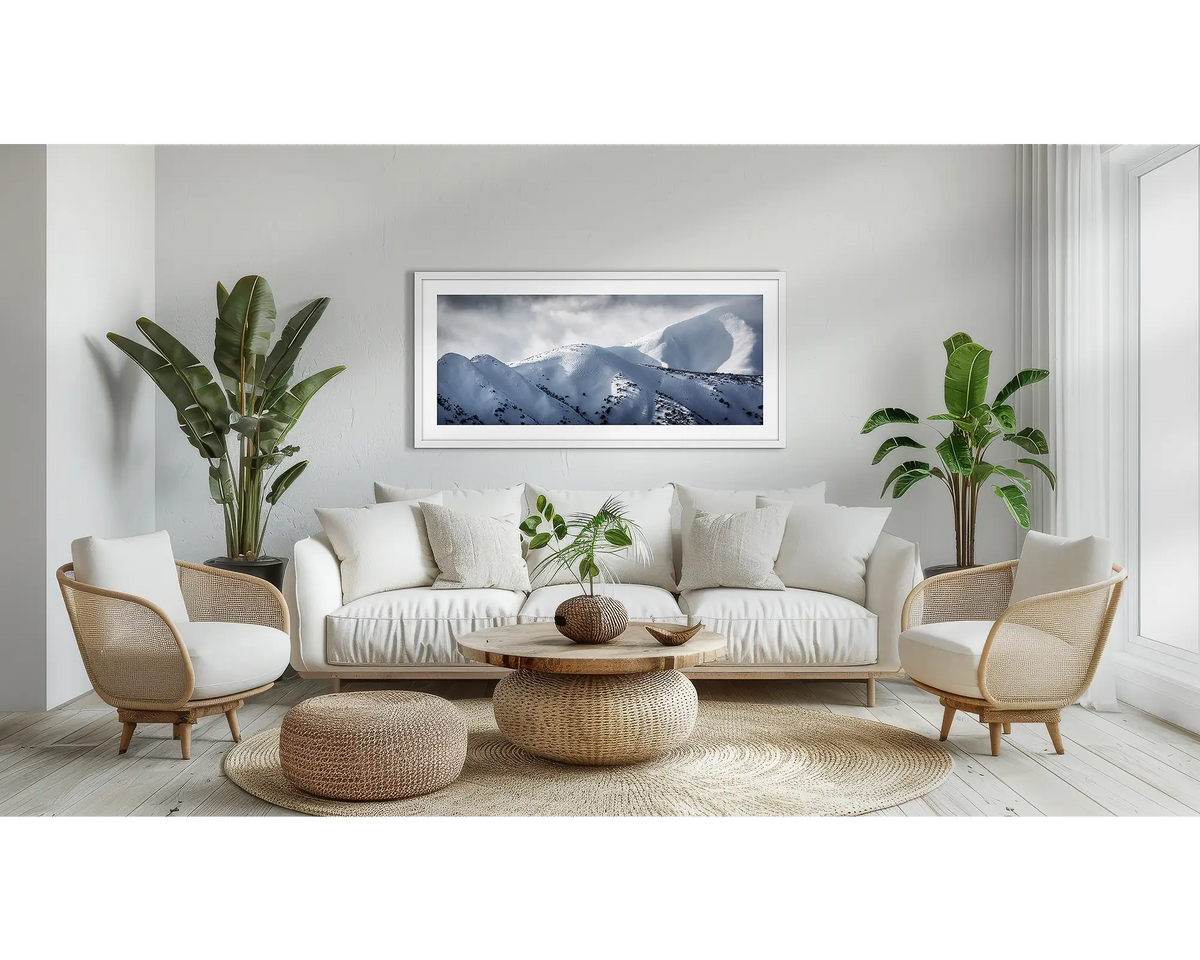 Journey to the Summit. Alpine wall art print, with a white frame, above a couch. 