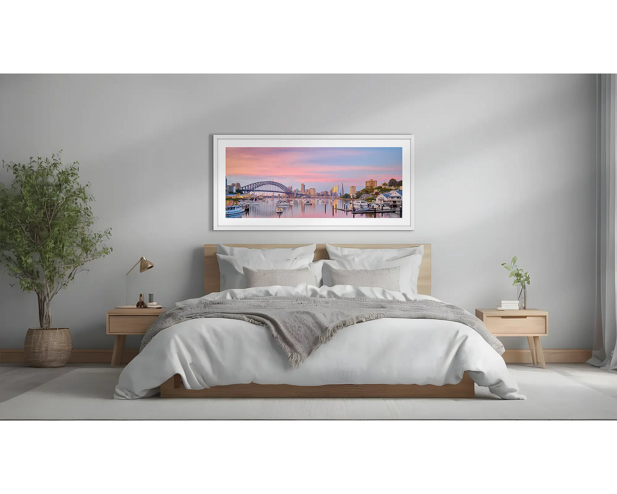 Lavender Sunrise. Sydney artwork in a white frame, above a bed. 