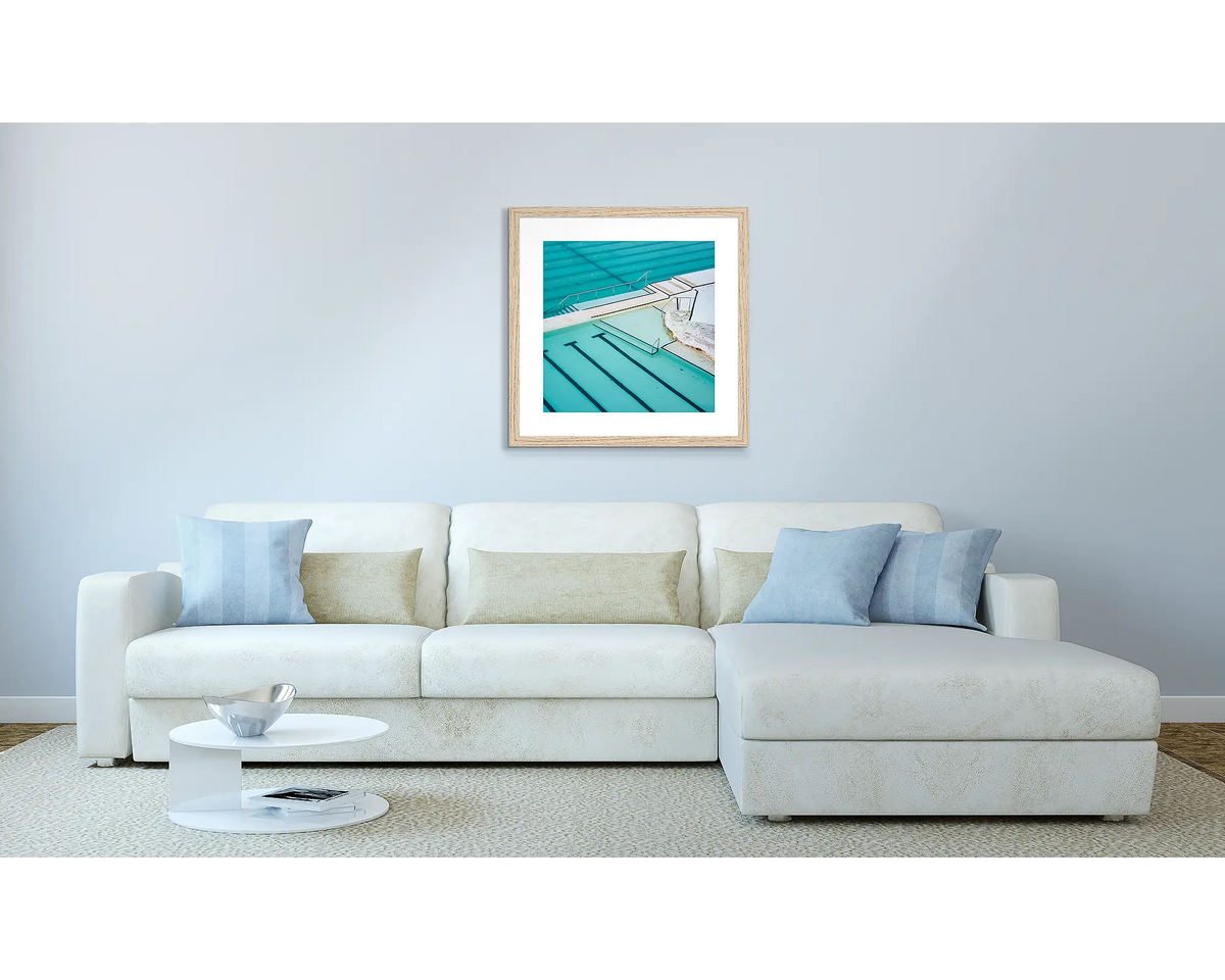 Lines. Bondi Icebergs Sydney artwork, in a Tasmanian Oak frame, above a couch.