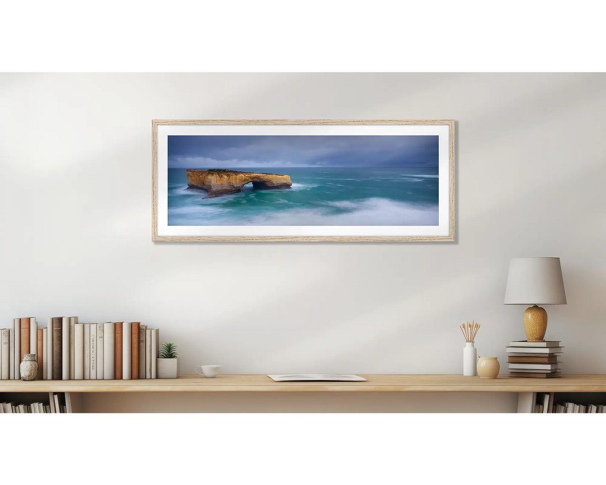 London Arch. Great Ocean Road wall art print, with a Tasmanian Oak frame, hung above a bookshelf. 