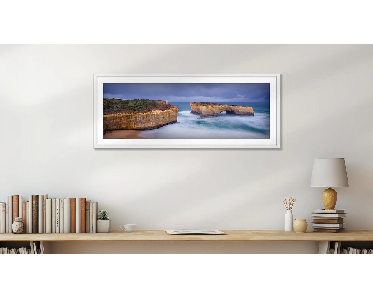 London Bridge Has Fallen Down. Great Ocean Road wall art print, with a white frame, hung above a bookshelf. 