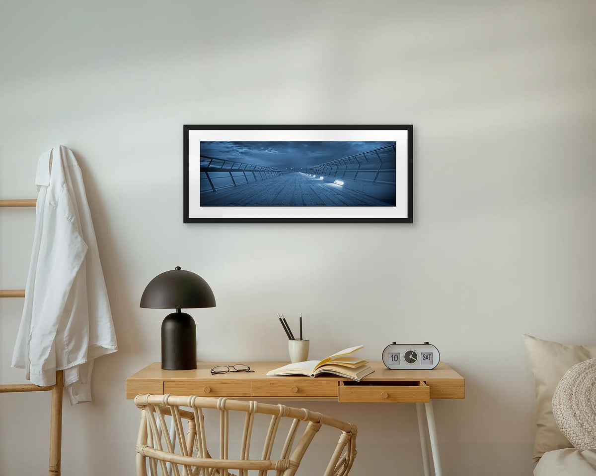 Lorne Pier. Panoramic wall art print, with a black frame, hung above a small side table.