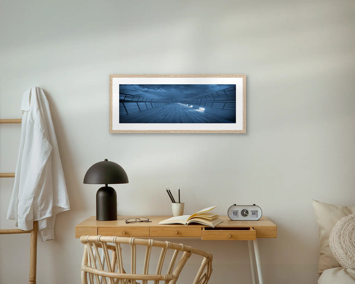 Lorne Pier. Panoramic wall art print, with a timber frame, hung above a small side table.