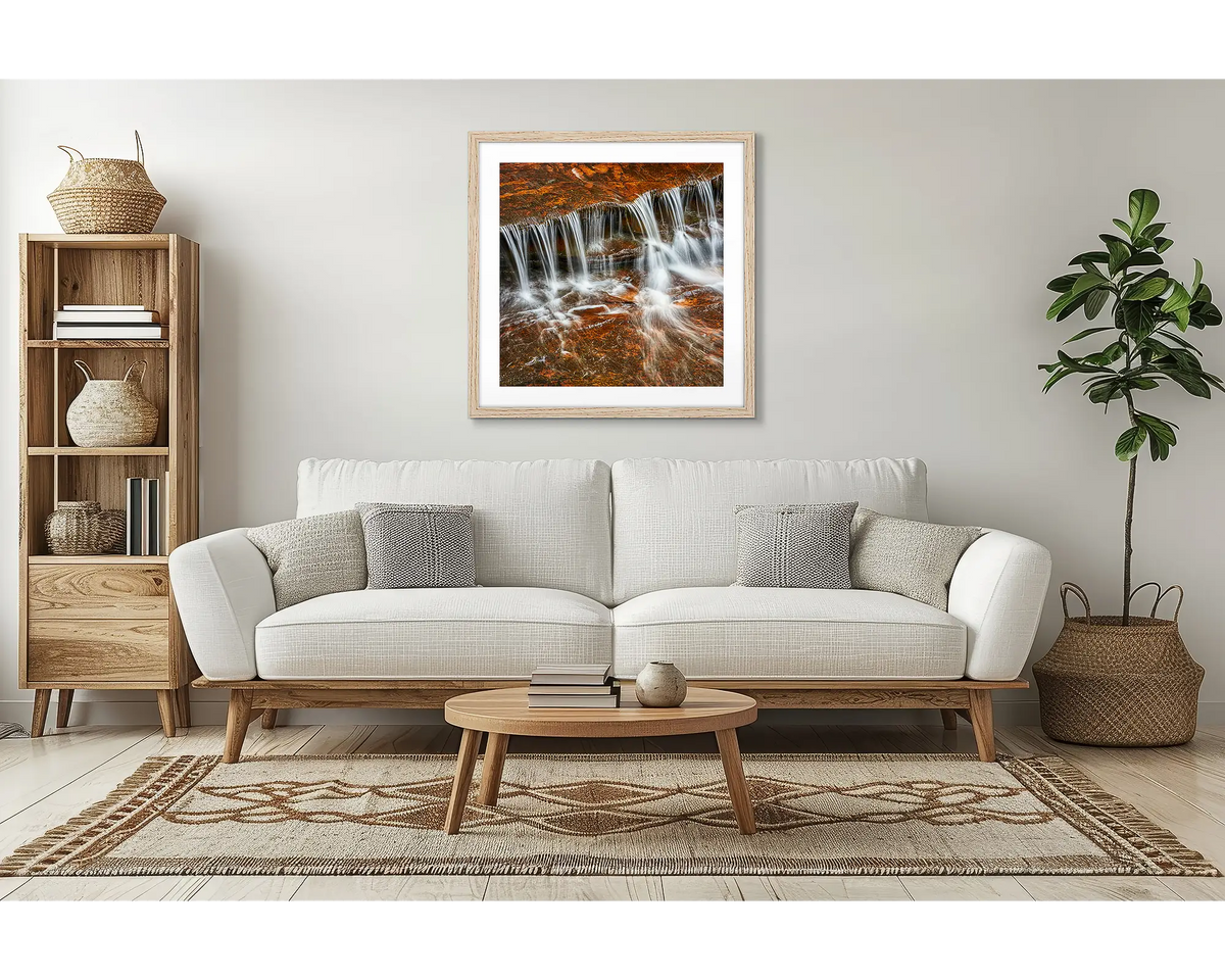 Motion. Waterfall wall art, with a timber frame in a lounge room, above a couch. 