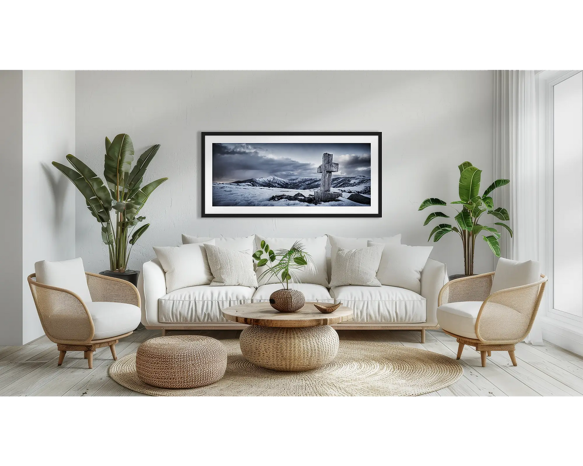 Mountain Cross. Alpine wall art print, with a black frame, above a couch. 