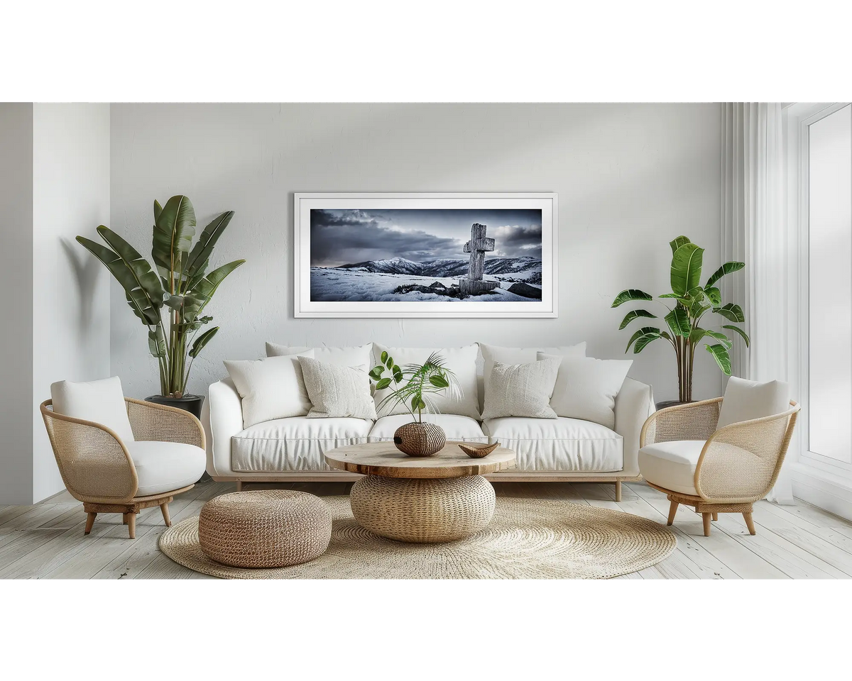 Mountain Cross. Alpine wall art print with a white frame, above a couch. 