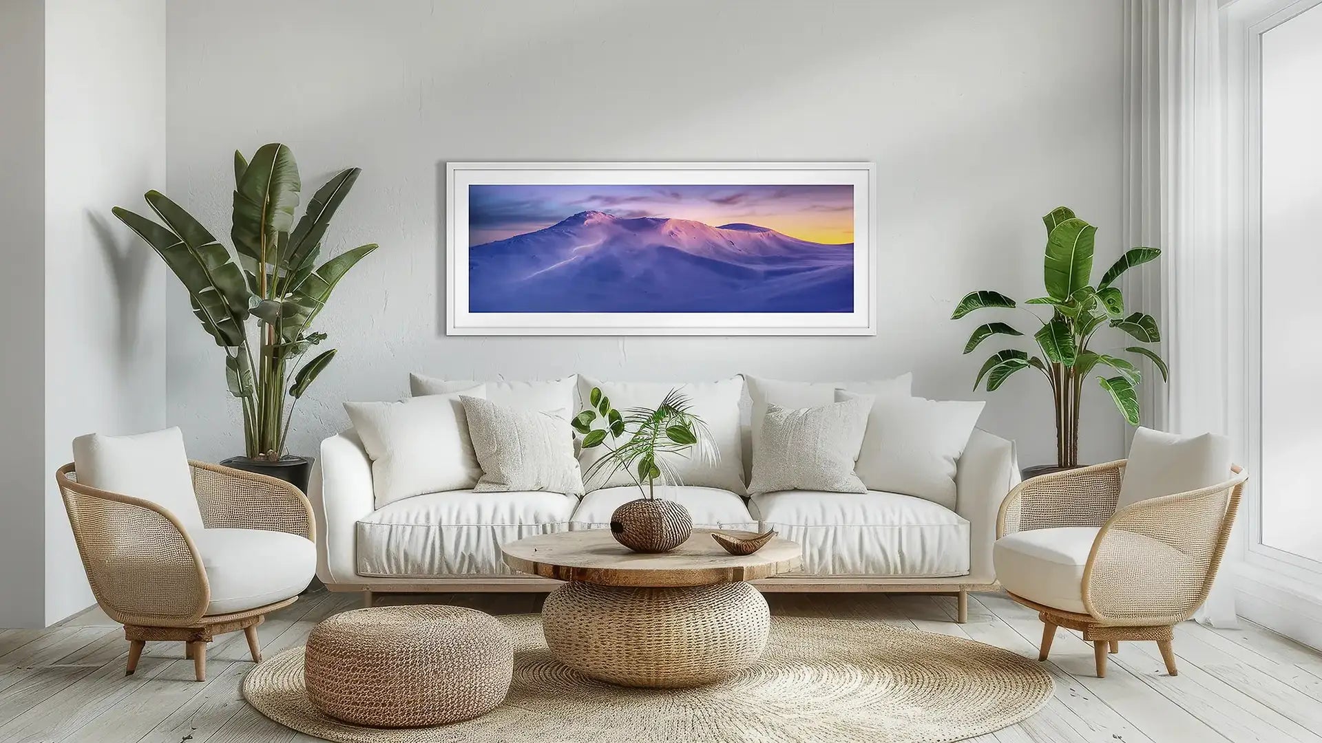 Mountain wall art print with white frame above couch.