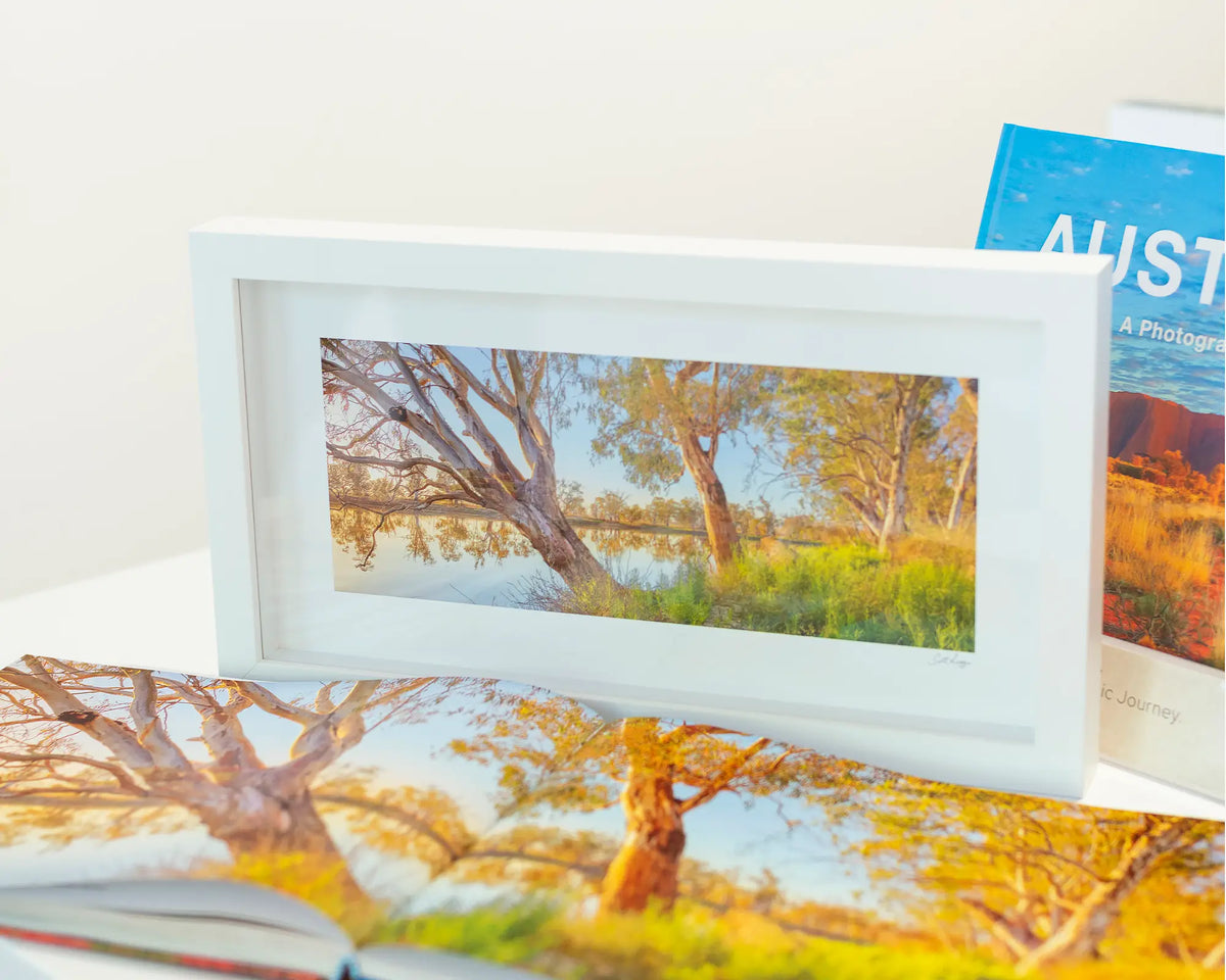 Murray Sunrise. Murray River small framed print with a white frame and a book.