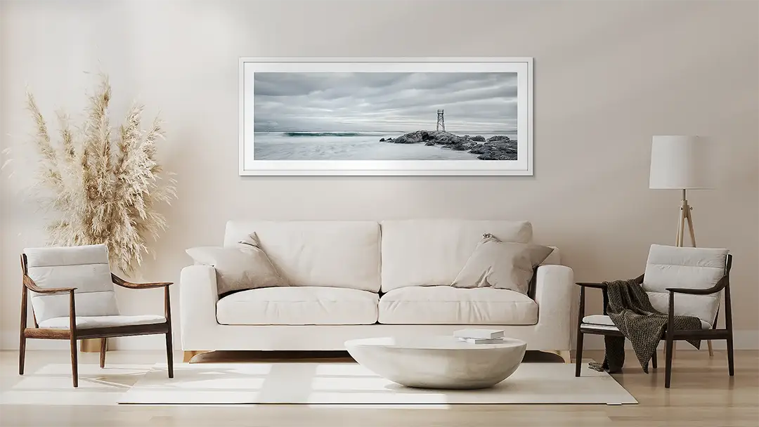 Neutral wall art, in white white frame above a couch.