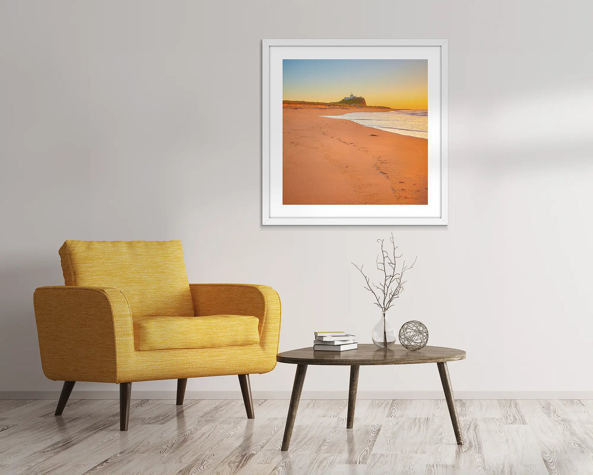 Newcastle Nostalgia. Nobbys beach sunrise, framed wall art print with a white frame, in an entry foyer. 