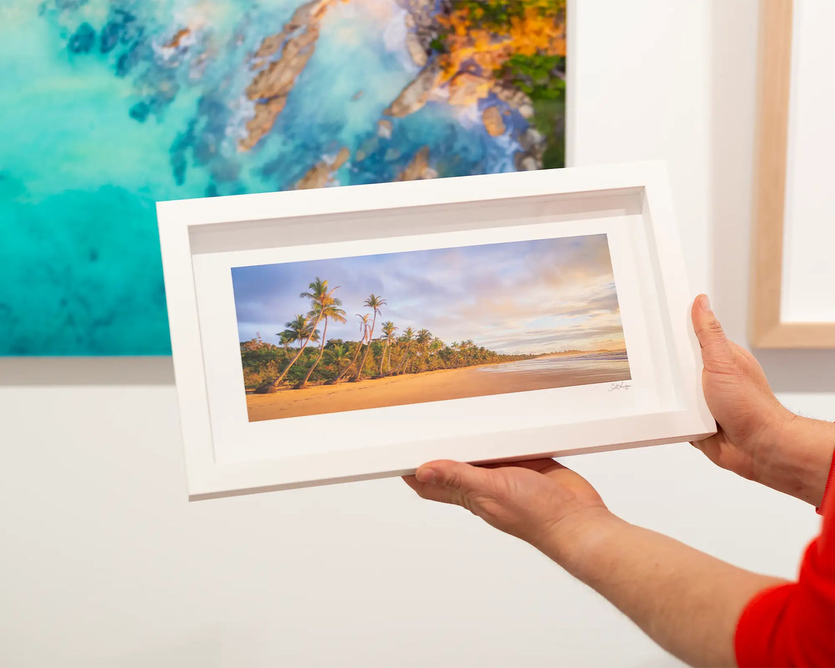 Ocean Breeze. Tree lined beach sunrise, small framed print with a white frame.