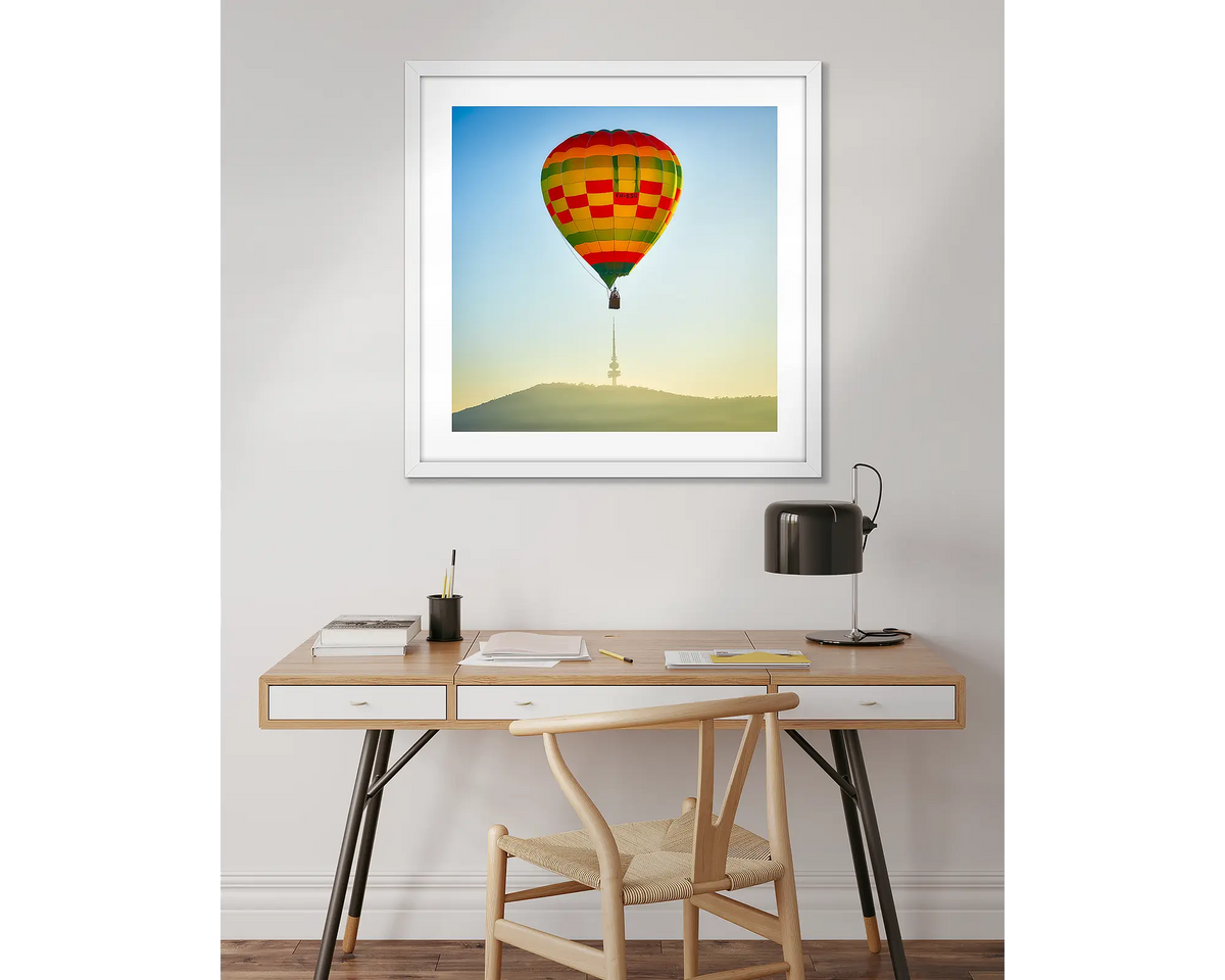 On Top. Framed Canberra balloon wall art, above a desk. 