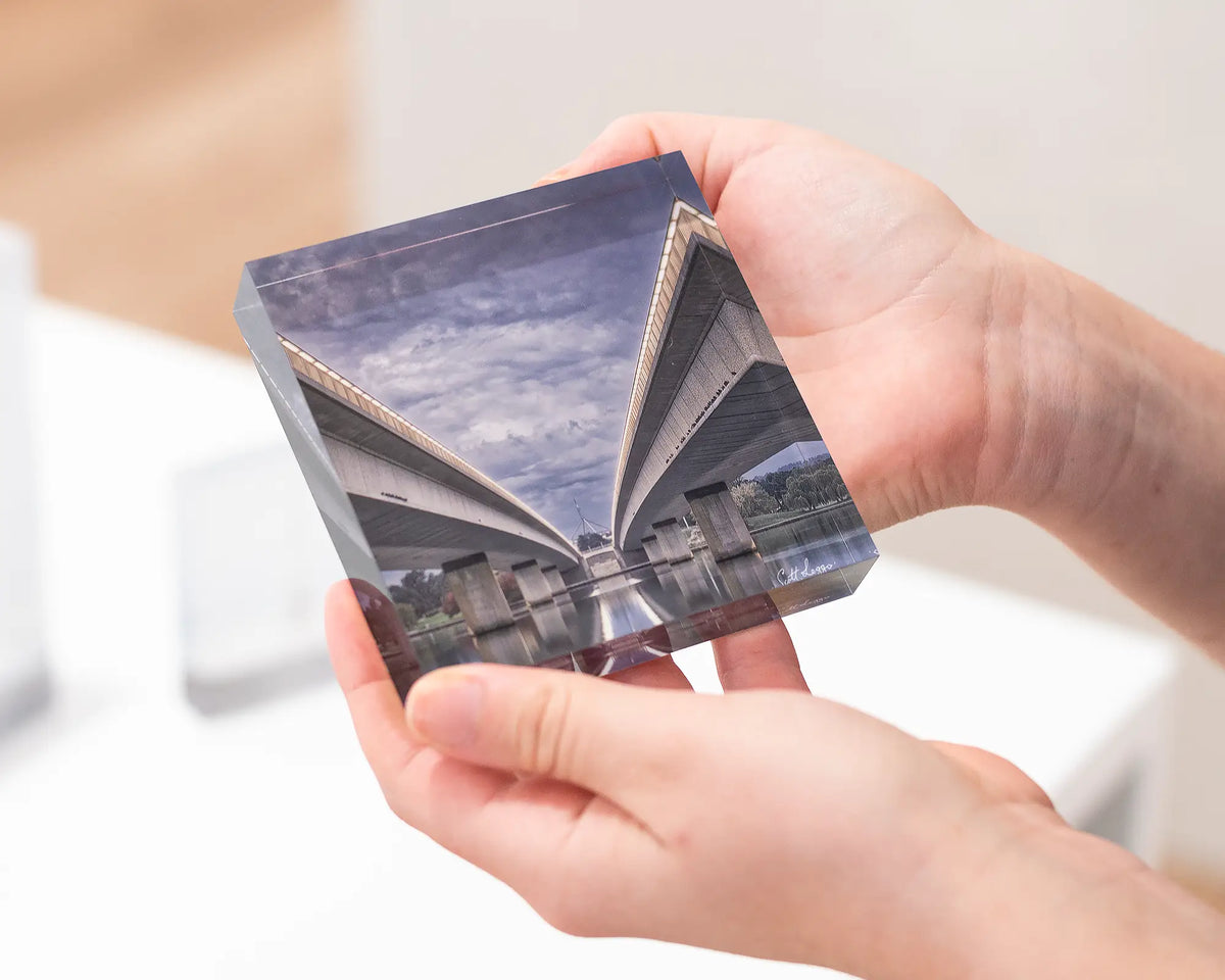 One Direction. Acrylic block of Commonwealth Avenue bridge, Canberra artwork being held.