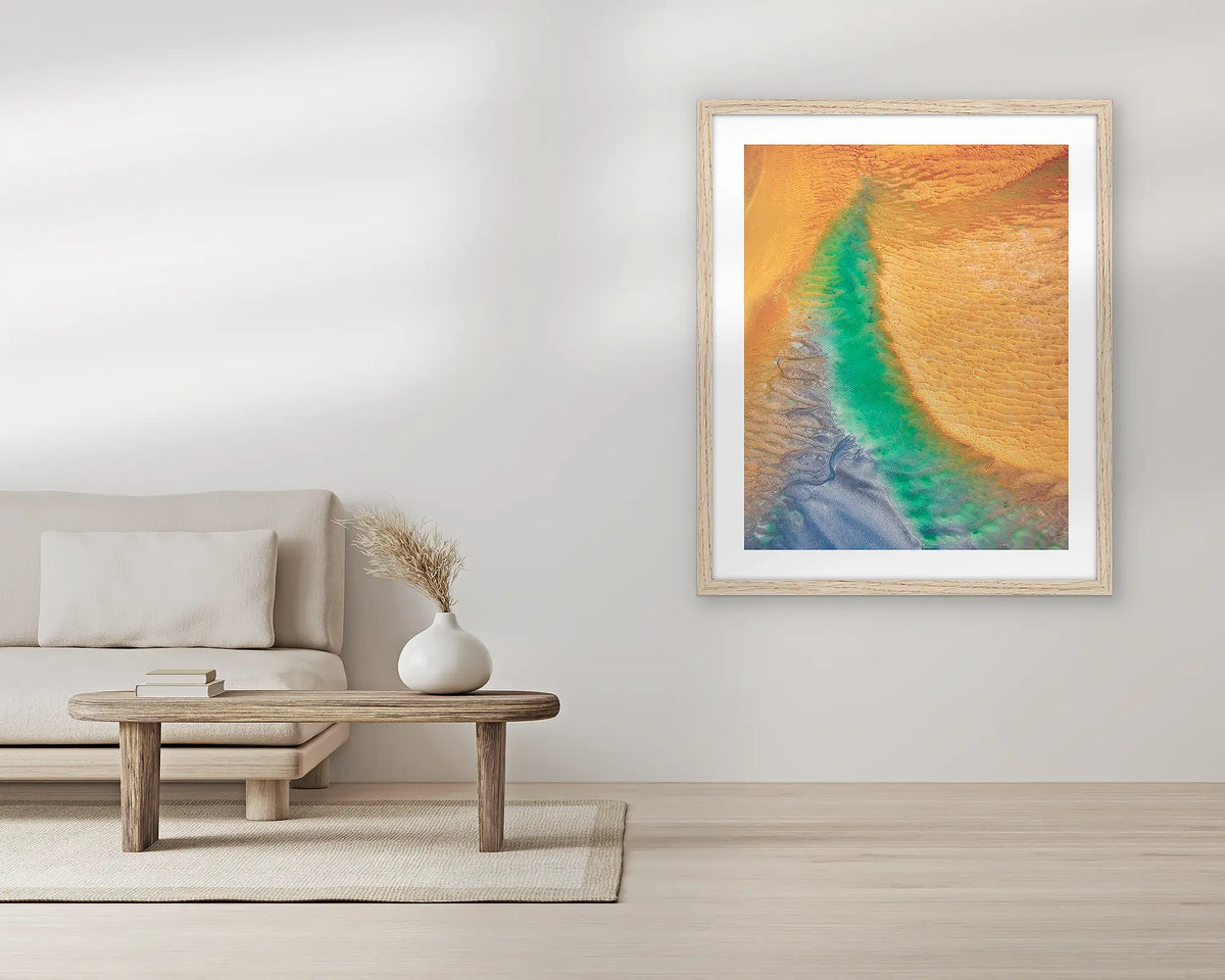 Opal Illusion. Aerial wall art print, with a Tassie oak frame, in a living room. 