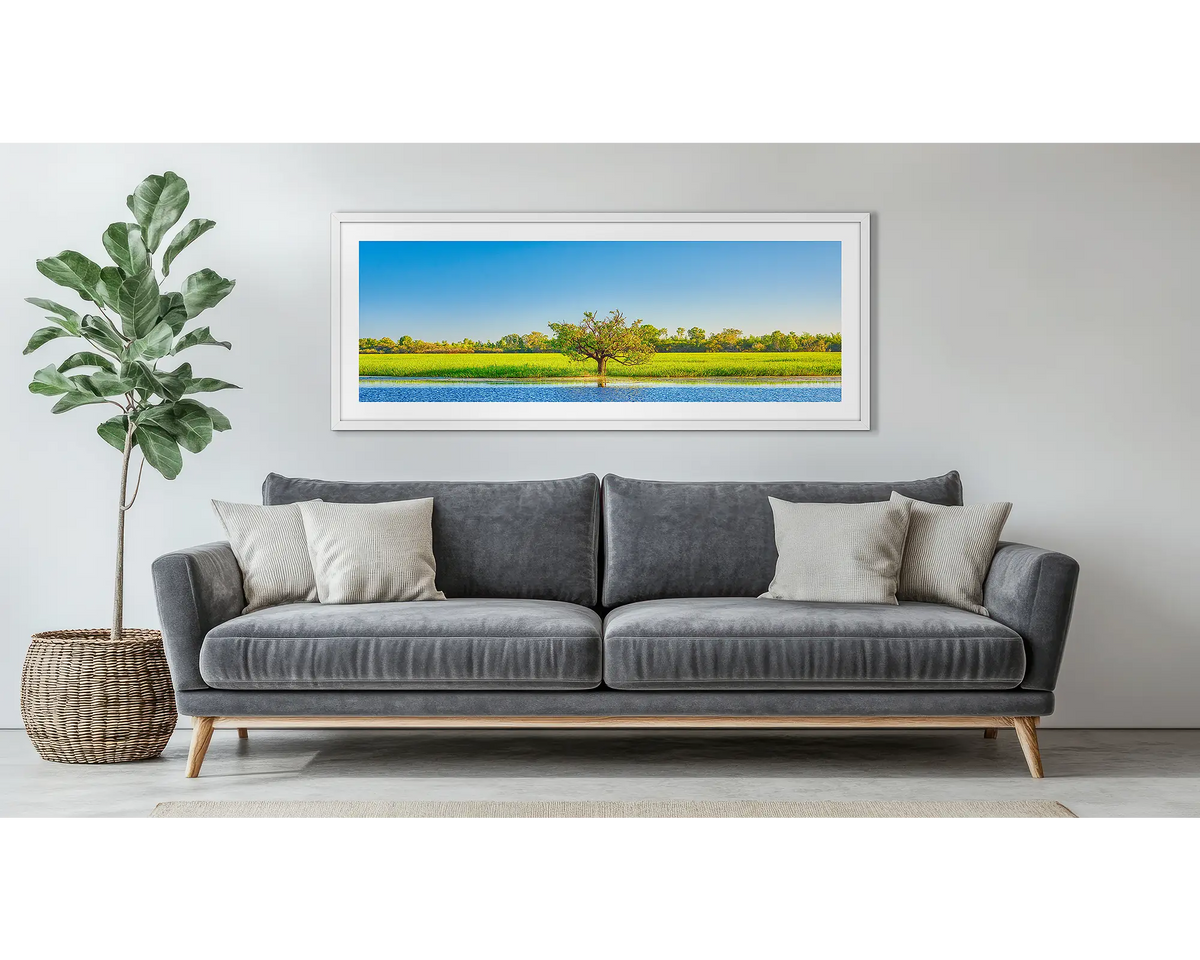 Outlier. Kakadu wall art, in a white frame, above a grey couch. 