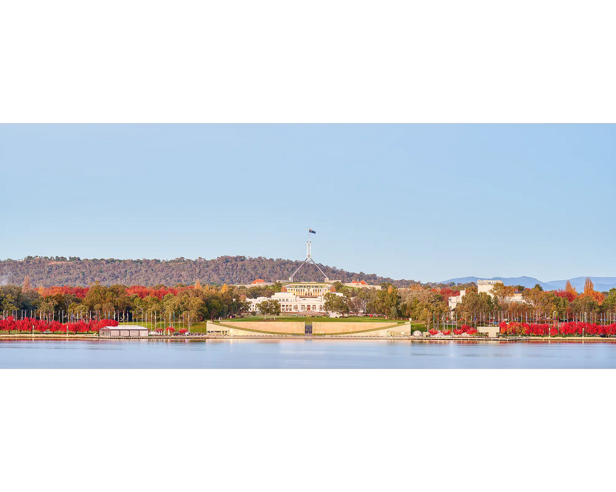 Red autumn trees use Lake Burley Griffin and in front of Old and New Parliament Houses, Canberra.