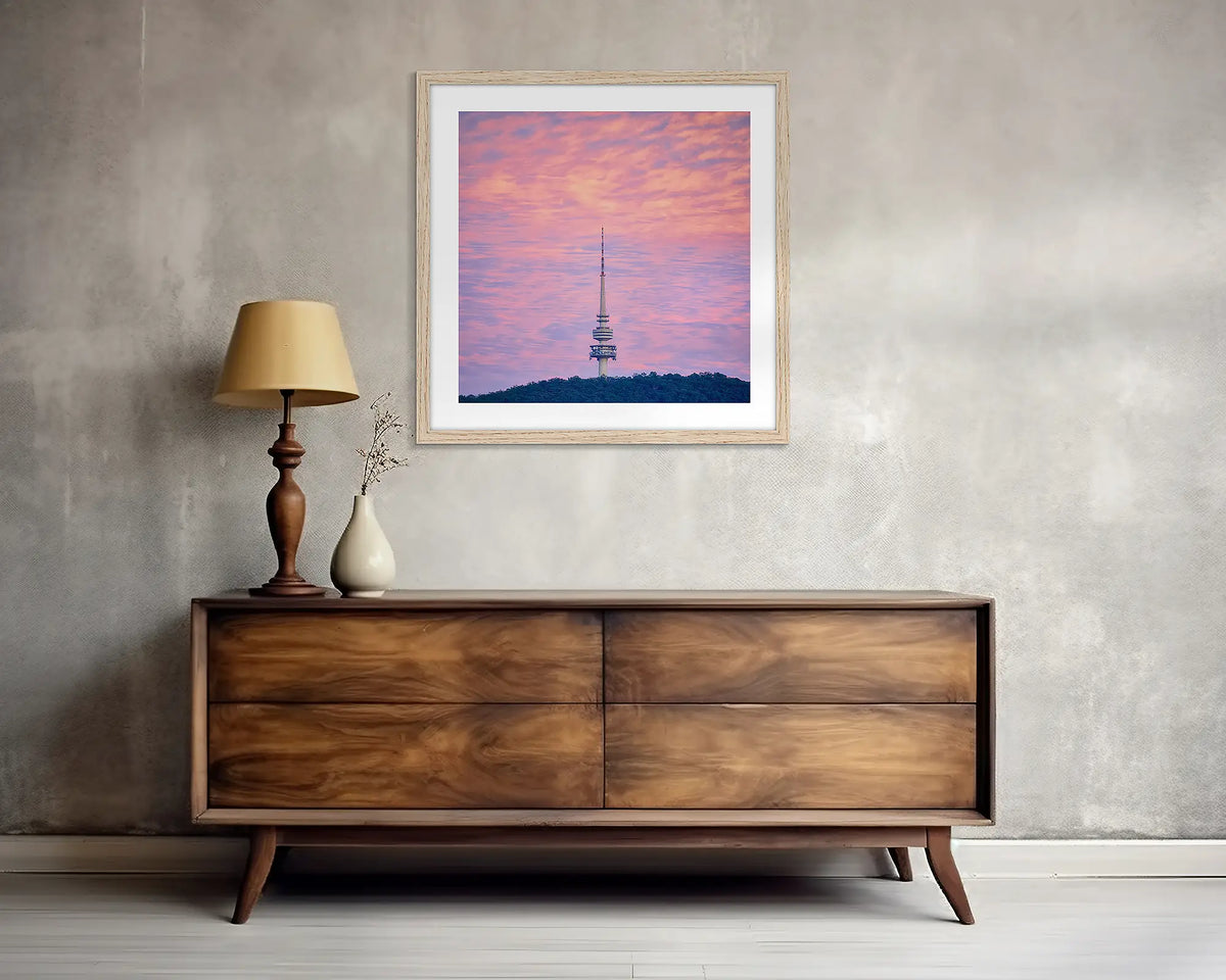 Pointer. Square, Canberra wall art print, with a wood frame, above a side table. 