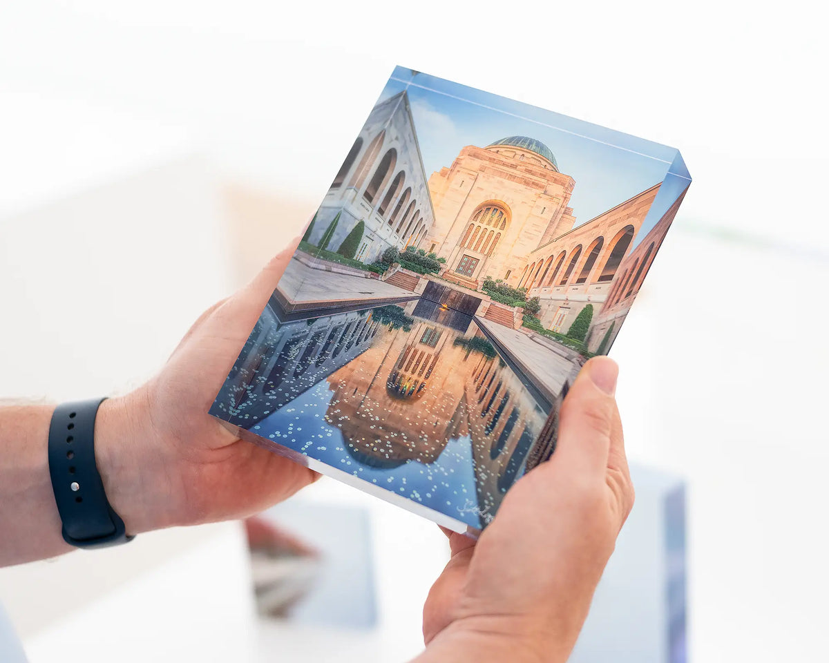 Pool of Reflection. Acrylic block of the Australian War Memorial at sunset. Canberra artwork being held.