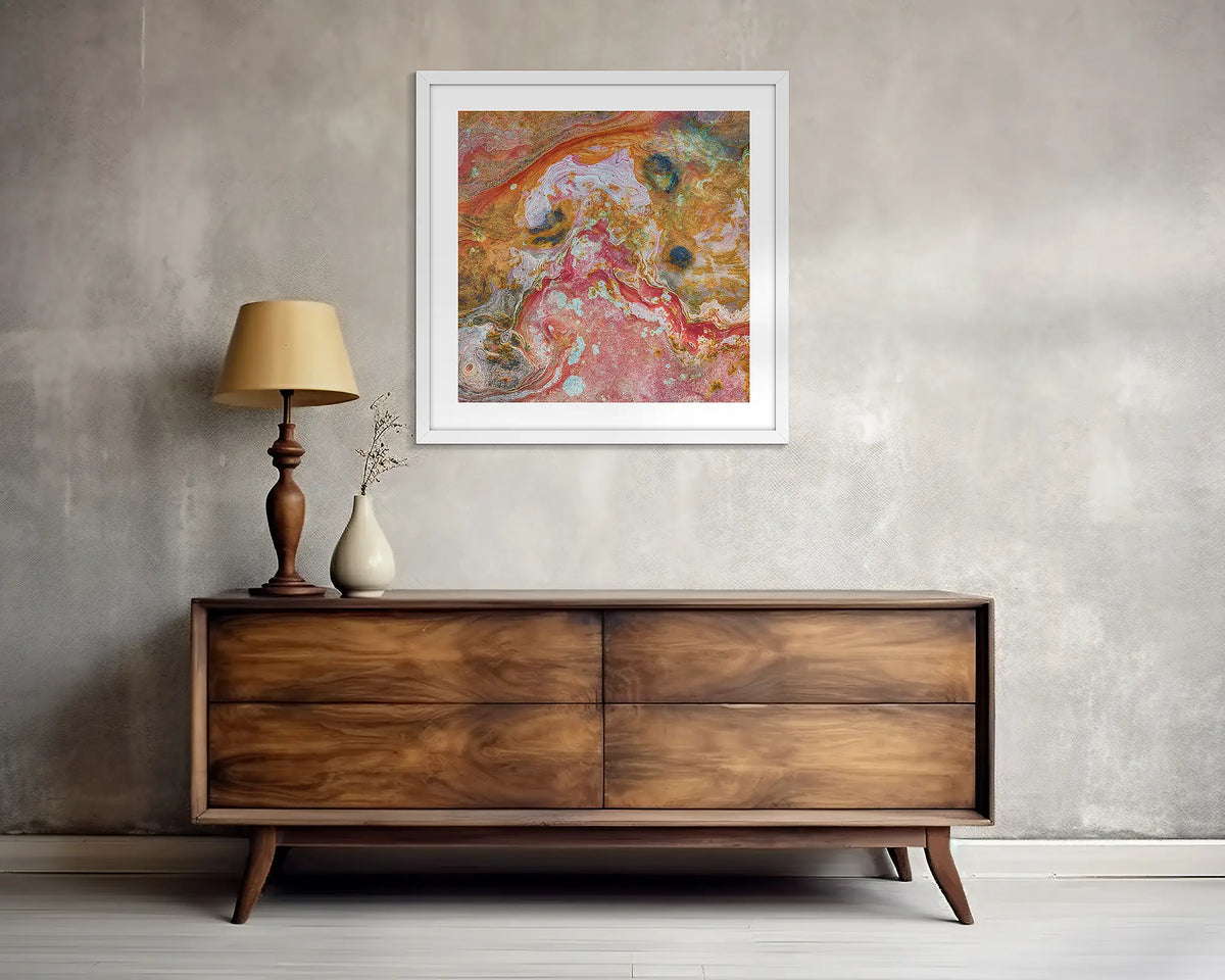 Rainbow Rock. Square, abstract wall art print, with a white frame, above a side table. 