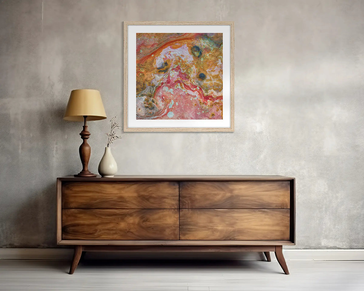 Rainbow Rock. Square, abstract wall art print, with a wood frame, above a side table. 