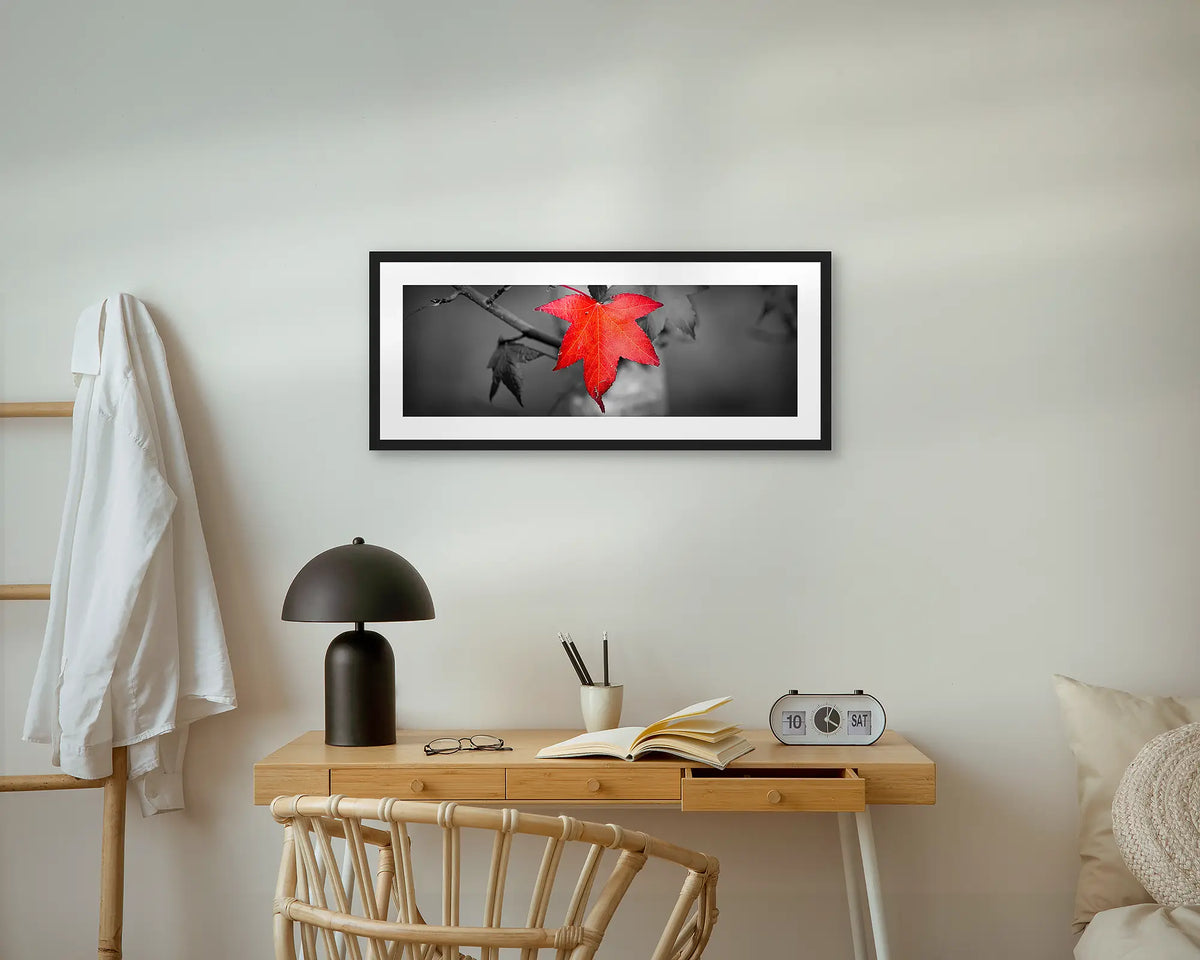 Red Leaf. Wall art print with a black frame, hung above a small desk. 