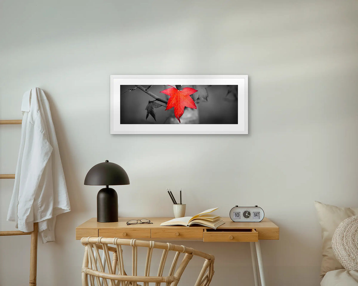 Red Leaf. Wall art print with a white frame, hung above a small desk. 