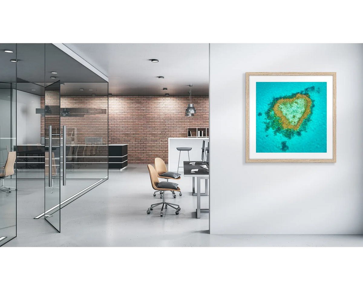 Reef Romance. Heart reef, Great Barrier reef wall art print with a timber frame, in a modern office. 