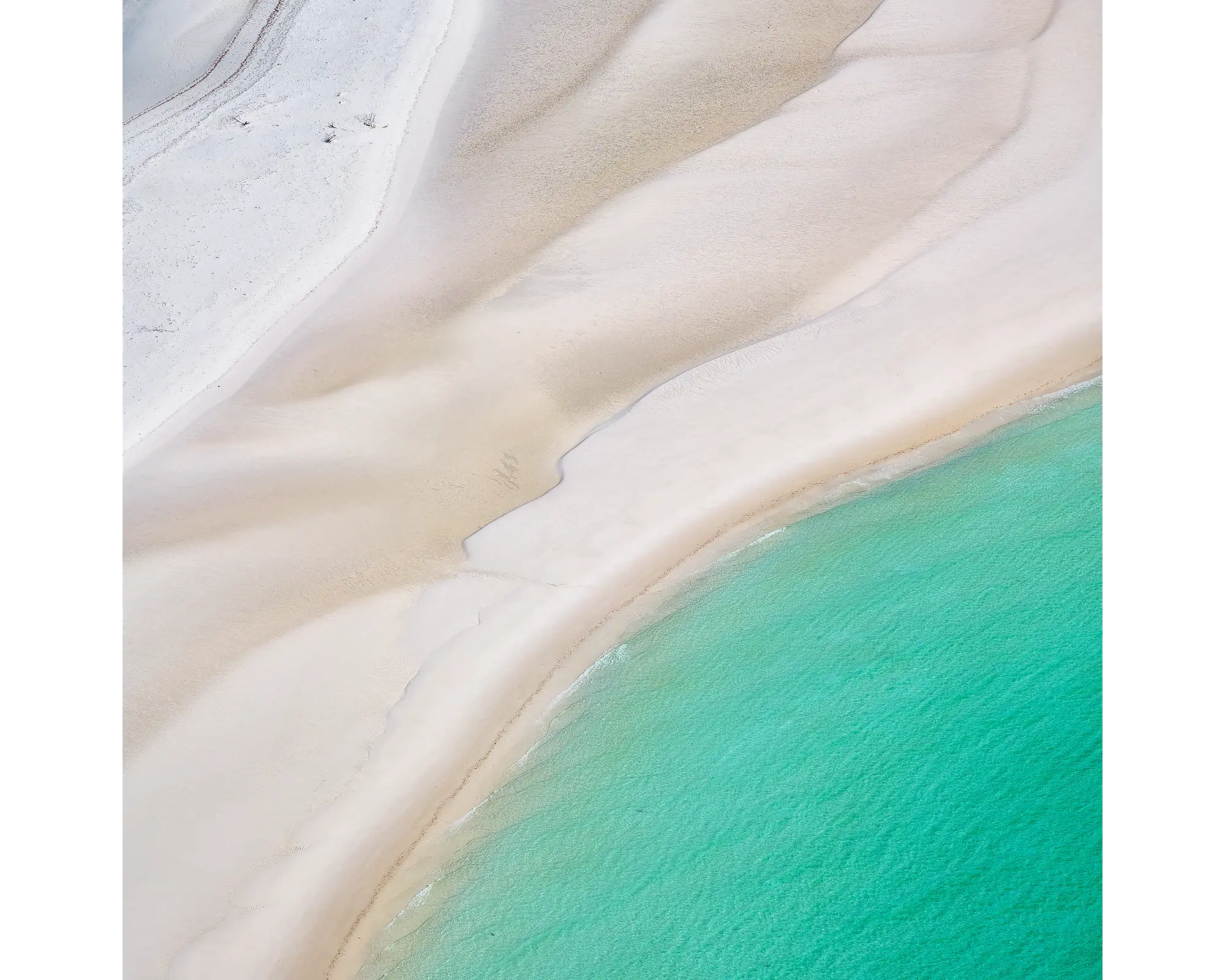 Aerial view of white sand and aqua water at Whitehaven Beach, Whitsunday Island, Queensland. 