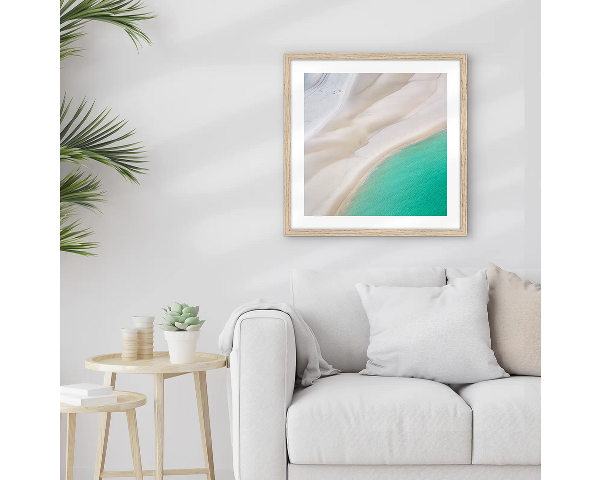 Ripples. Framed Whitsundays wall art print, with a timber frame, hung above a couch.