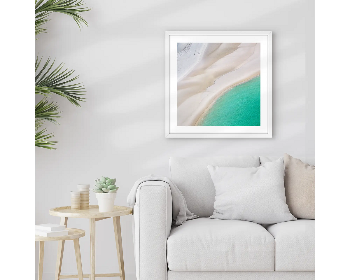 Ripples. Framed Whitsundays wall art print, with a white frame, hung above a couch.