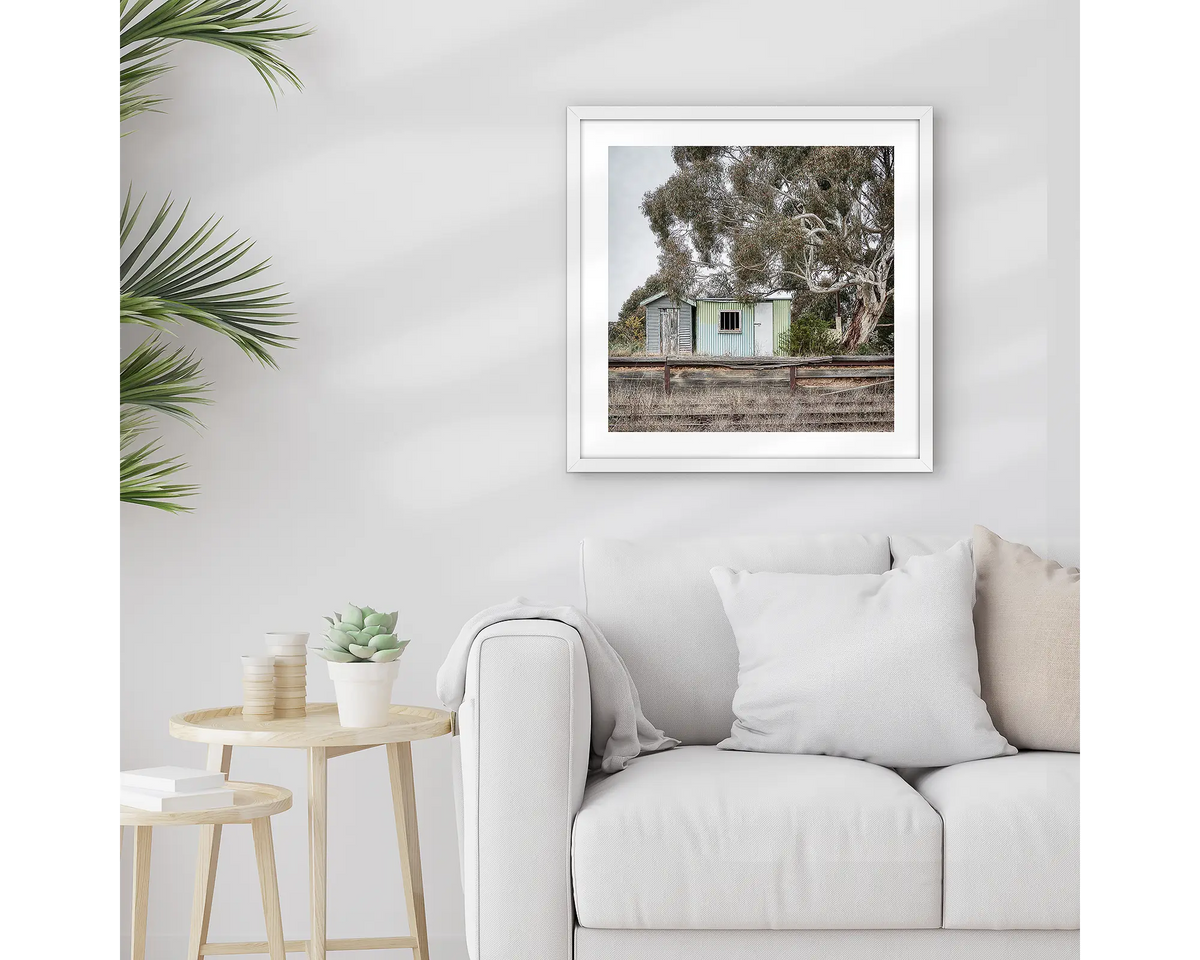 Royalla. Framed train station wall art print with a white frame, hung above a couch.