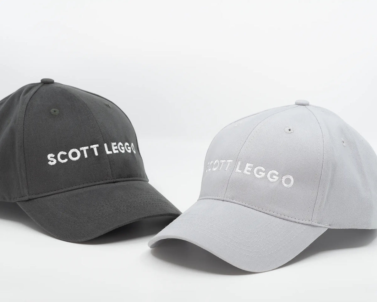 Scott Leggo baseball cap in two colours on table.