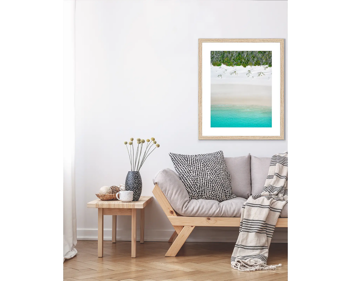 Sea Change. Abstract coastal wall art print, in a Tasmanian Oak frame, hanging above a couch.