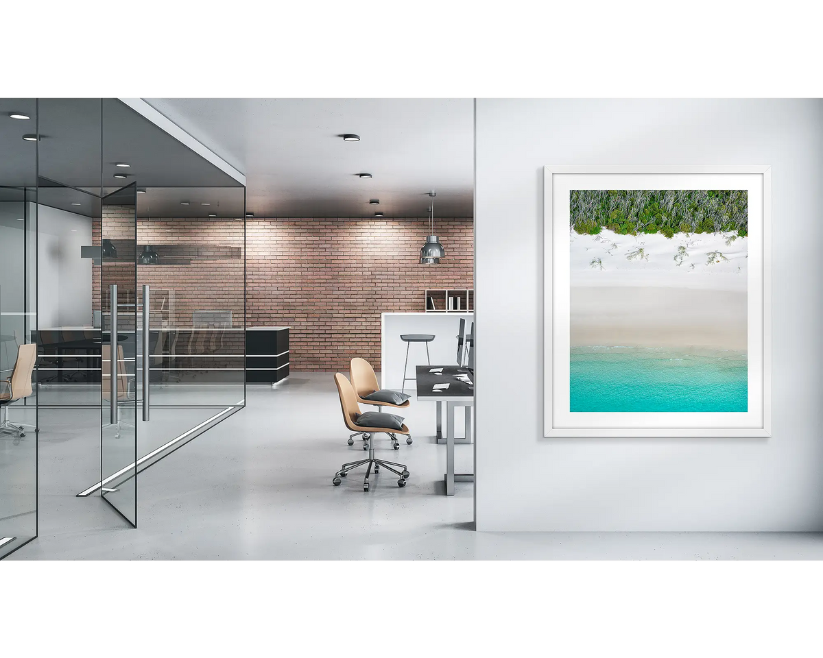 Sea Change. Whitehaven beach wall art print with a white frame, in a modern office. 