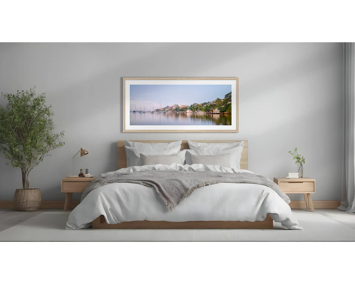 Seclusion. Sydney Harbour wall art, with a Tasmanian Oak frame, above a bed. 