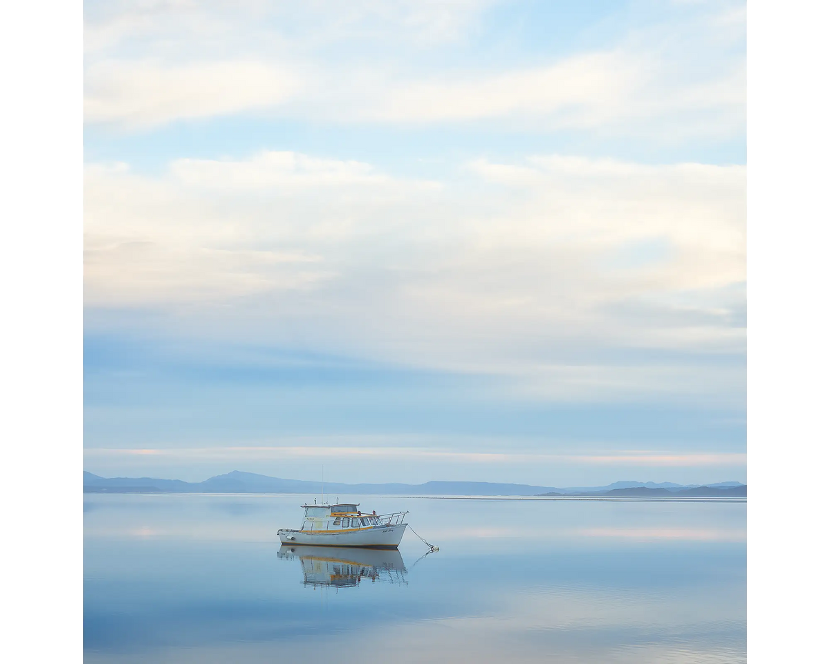 Moored boat on the still waters of Macquarie Harbour, Tasmania. 