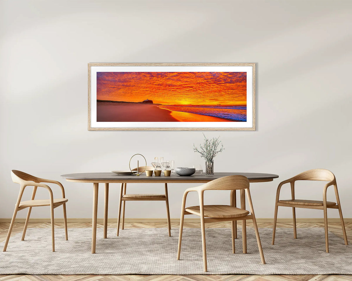 Sky Fire. Nobbys Beach, Newcastle, sunrise wall art print, with a Tassie oak frame, on a dining room wall.