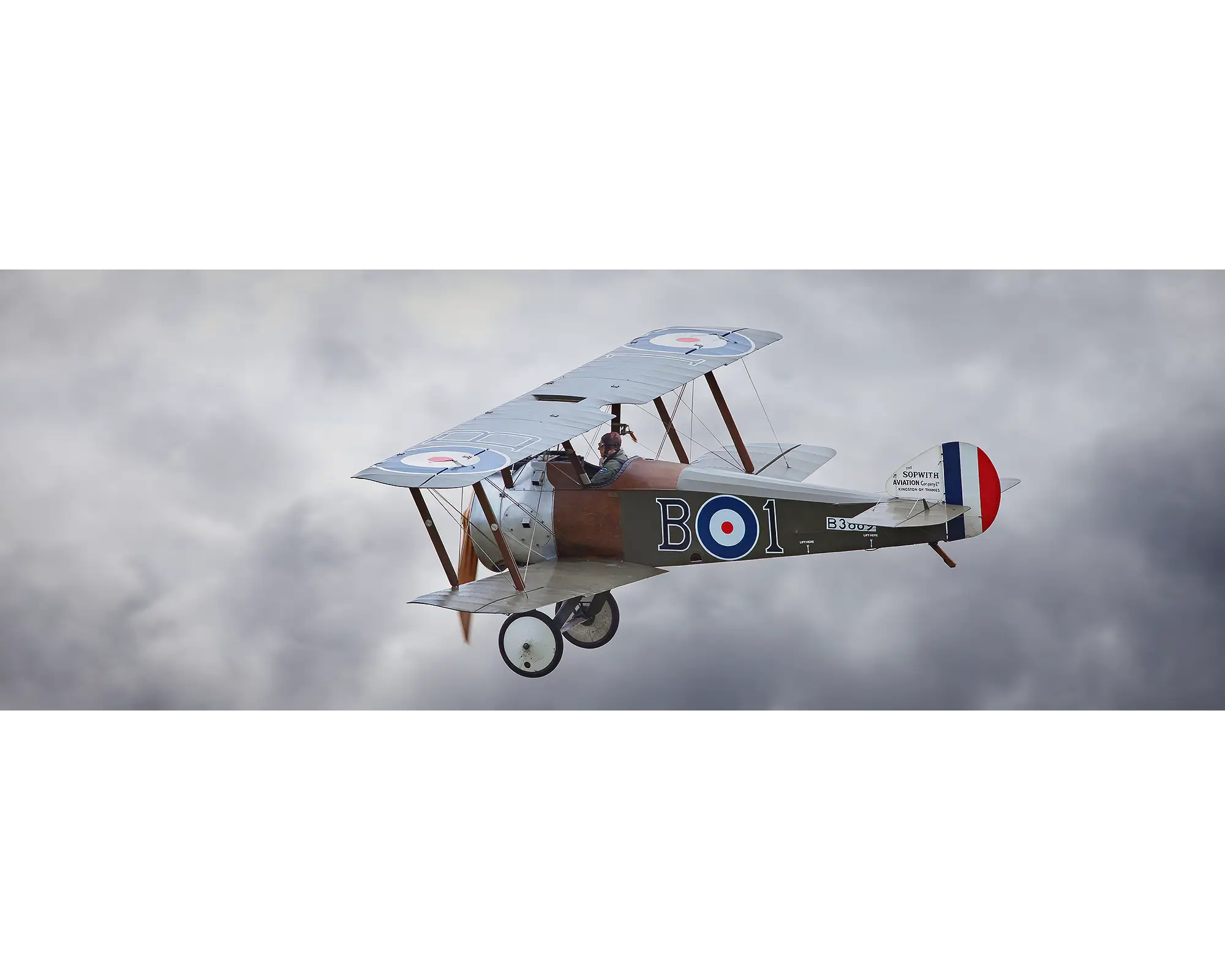 Sopwith Camel flying against a backdrop of clouds. 