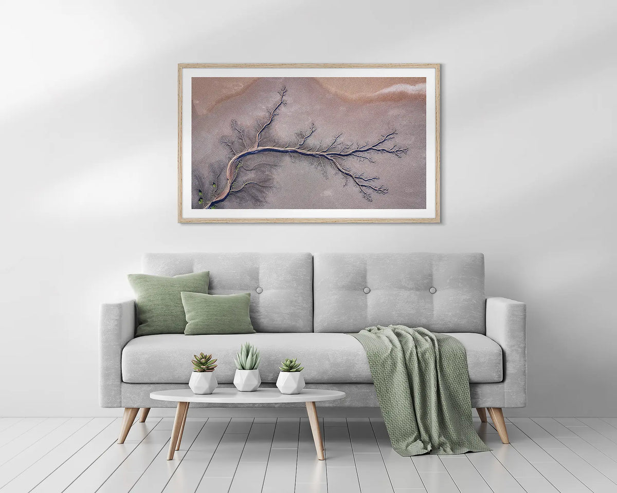 Sprawl. Kimberley, abstract framed wall art print, with a timber frame, above a couch. 