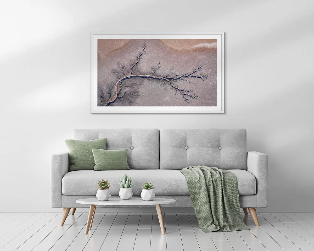 Sprawl. Kimberley, abstract framed wall art print, with a white frame, above a couch. 