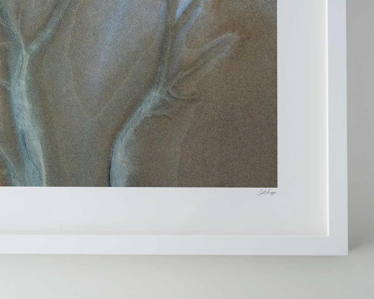 Spread. Tidal patterns of the Cambridge gulf in the Kimberley, Western Australia. Wall art in a white frame on a table.