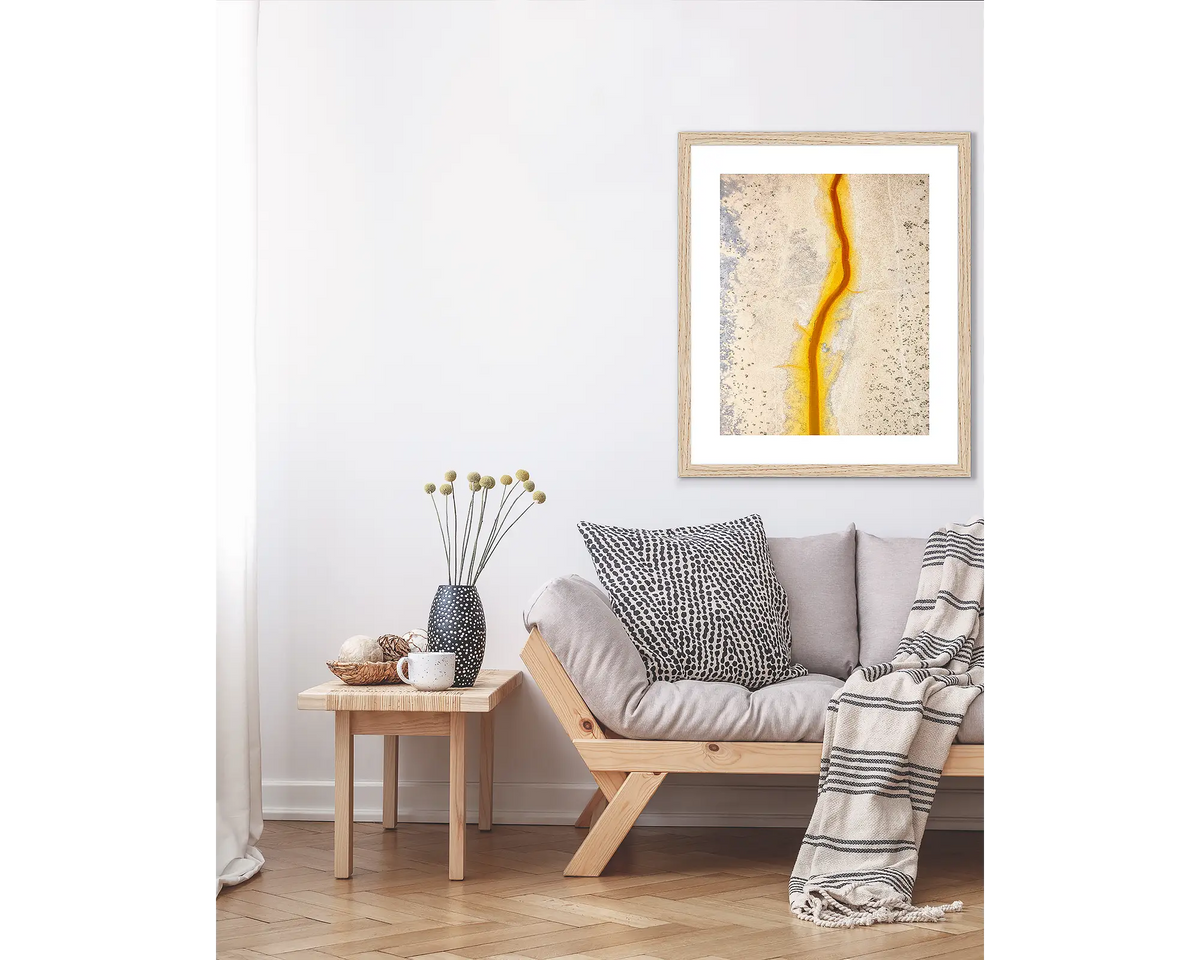 Strike. Abstract Kimberley wall art print, in a Tasmanian Oak frame, hanging above a couch.