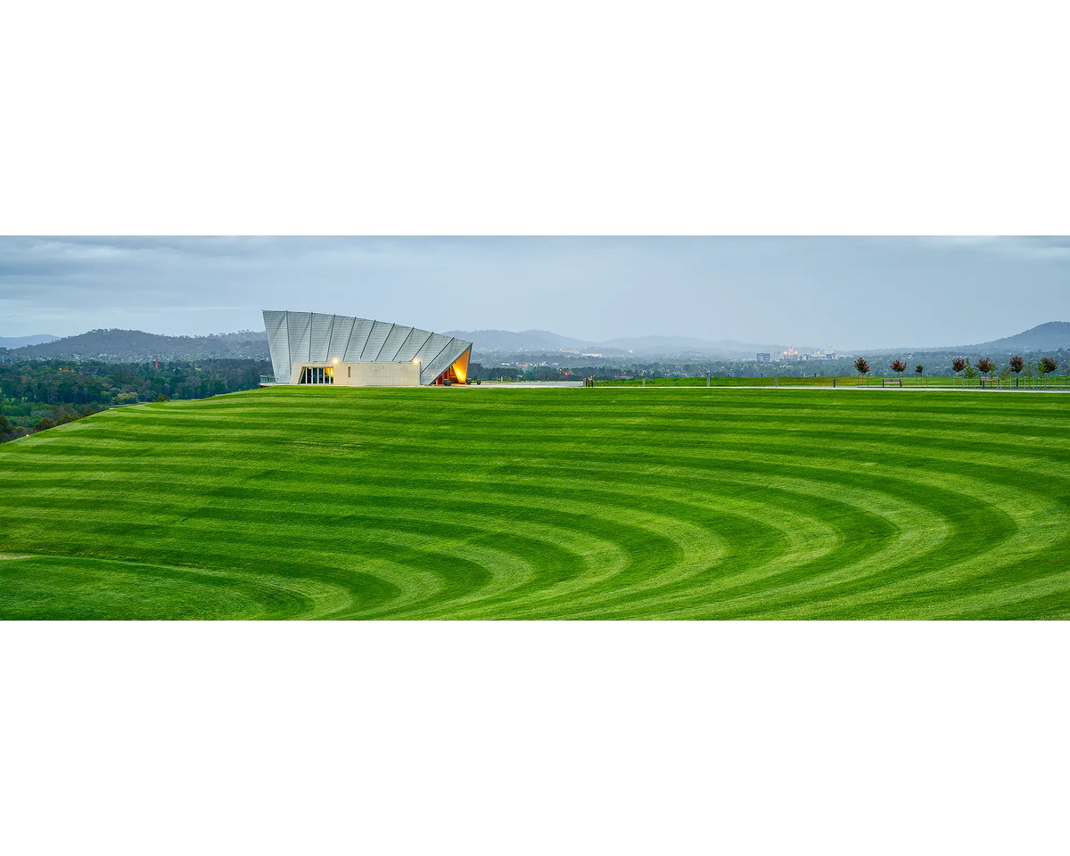 Freshly mown grass with visible stripes and storm clouds over Margaret Whitlam Pavilion, National Arboretum, Canberra. 