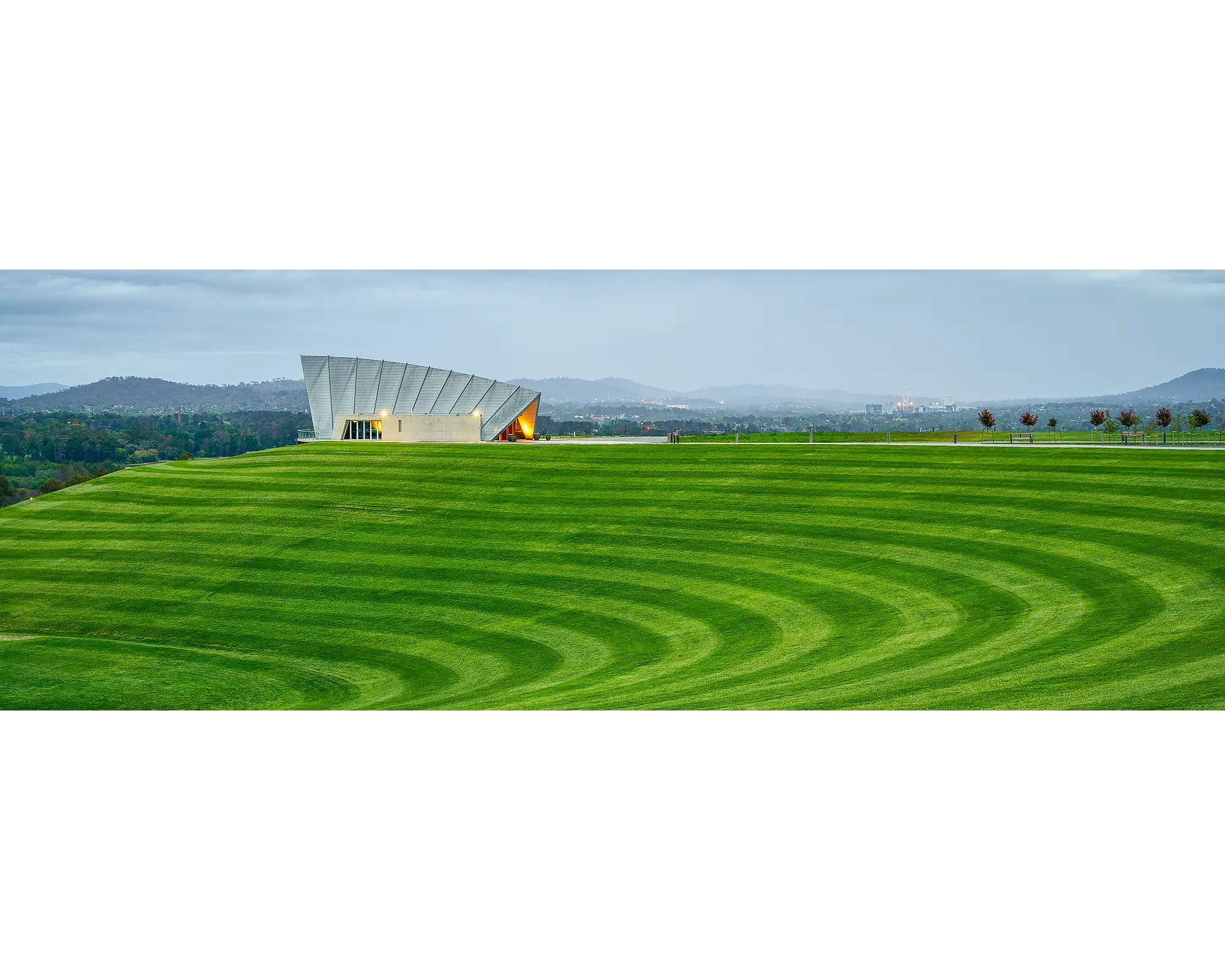 Freshly mown grass with visible stripes and storm clouds over Margaret Whitlam Pavilion, National Arboretum, Canberra. 