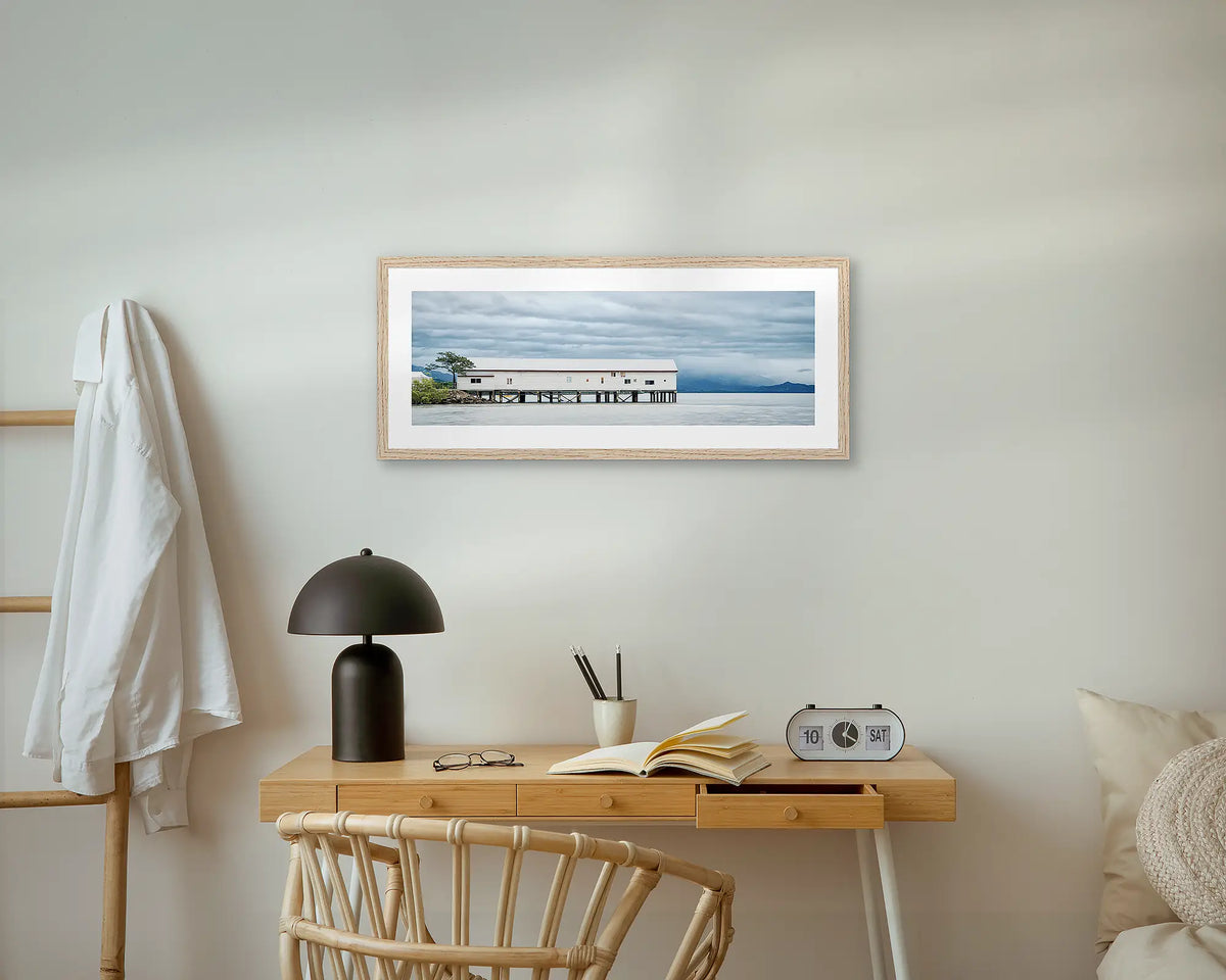 Sugar Wharf. Port Douglas wall art print, with a timber frame, above a small desk.