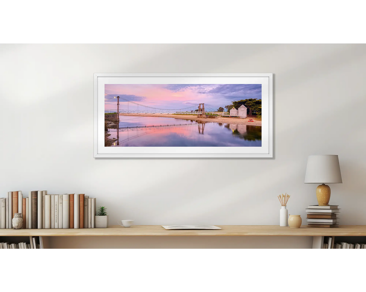 Swing Bridge. Lorne wall art print, with a white frame, hung above a small office shelf. 