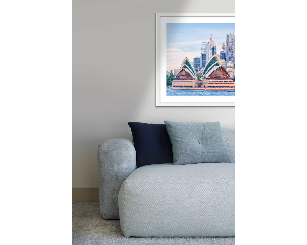 Sydney Views. Opera House, framed wall art print, with a white frame, hung above a couch.