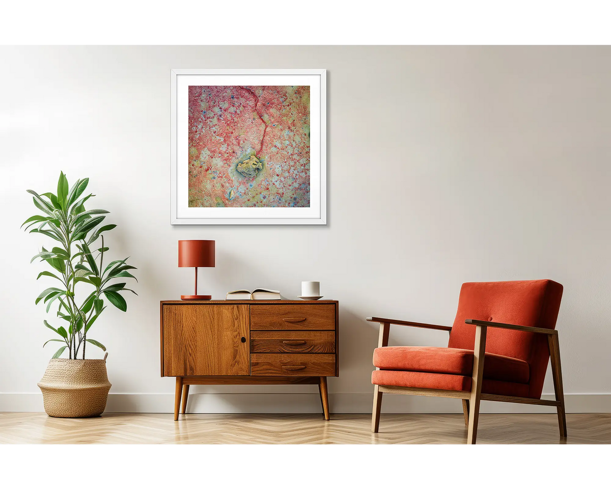 Tail End. Red sand beach wall art print, with a white frame, hung above a couch.