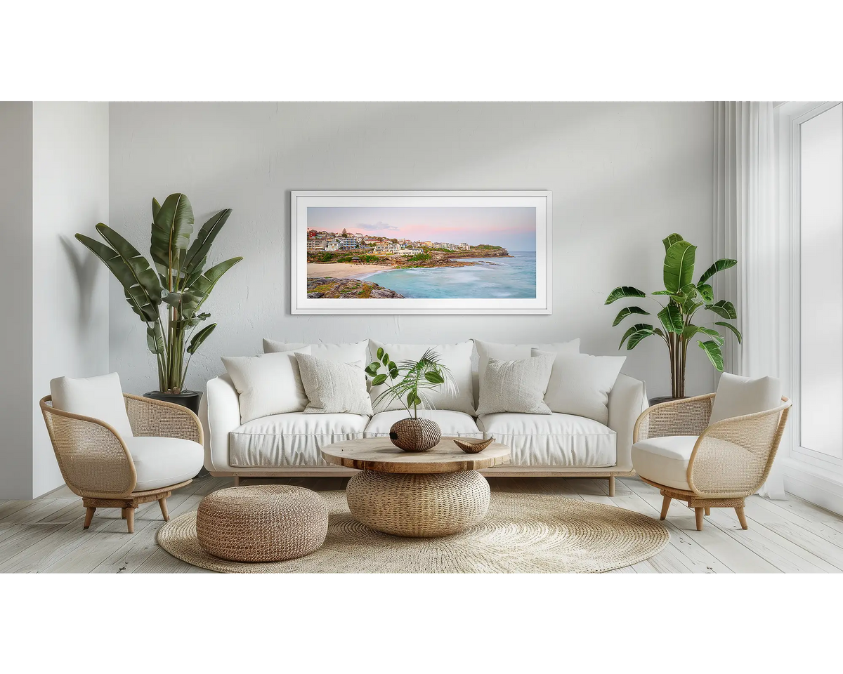 Tama Sundown. Tamarama beach sunset artwork, in a white frame, above a couch. 